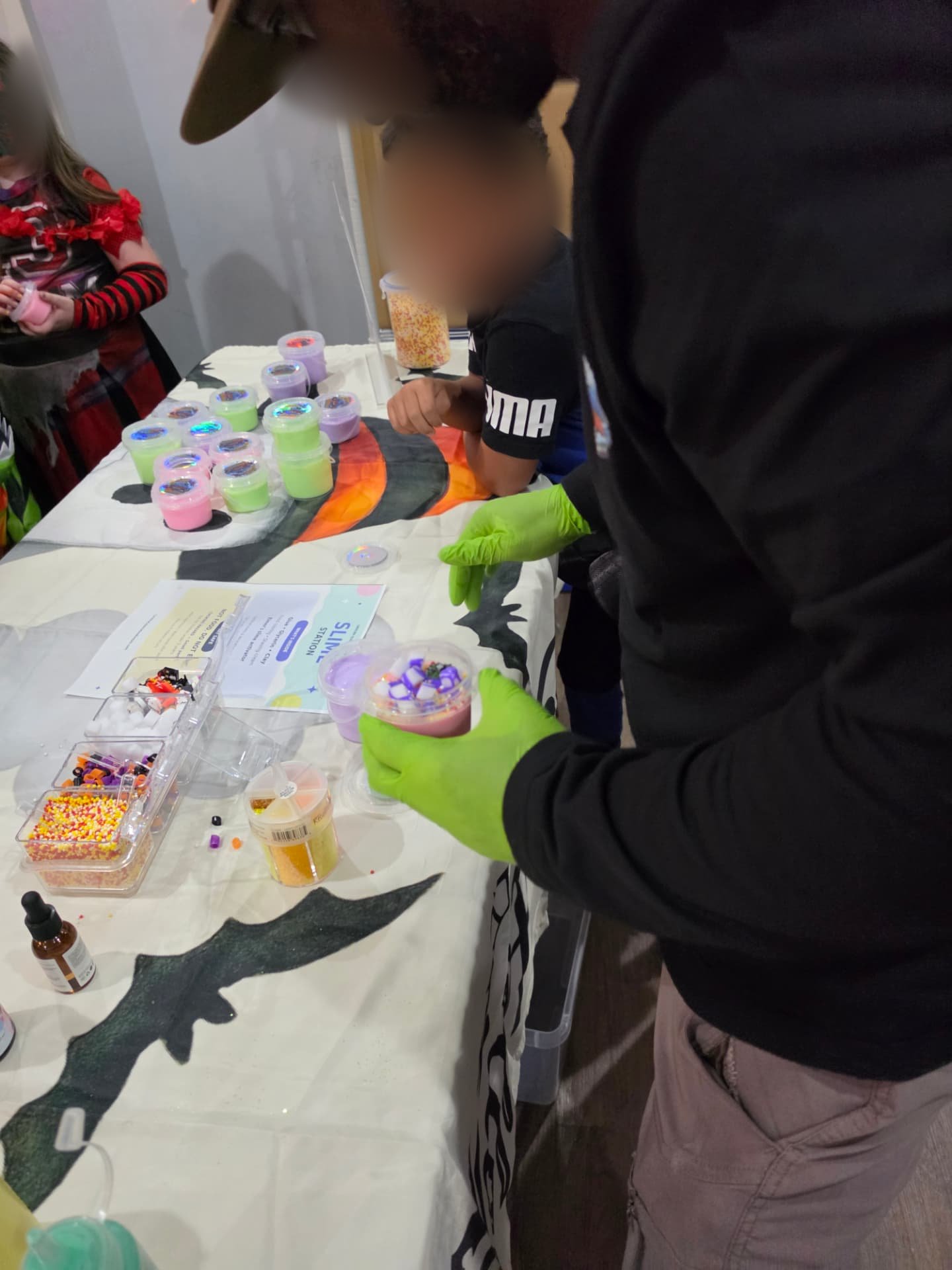 Toppings added to a slime cup by a gloved host