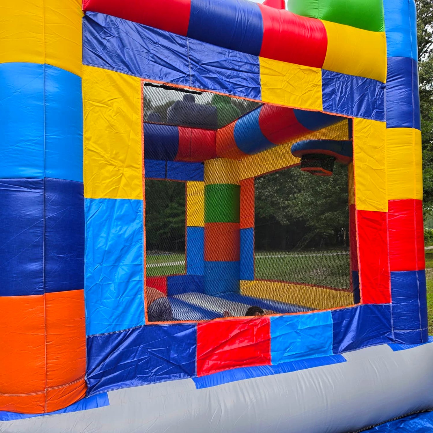 Inside the Block Party bounce house rental showing the basketball hoop and full mesh netting