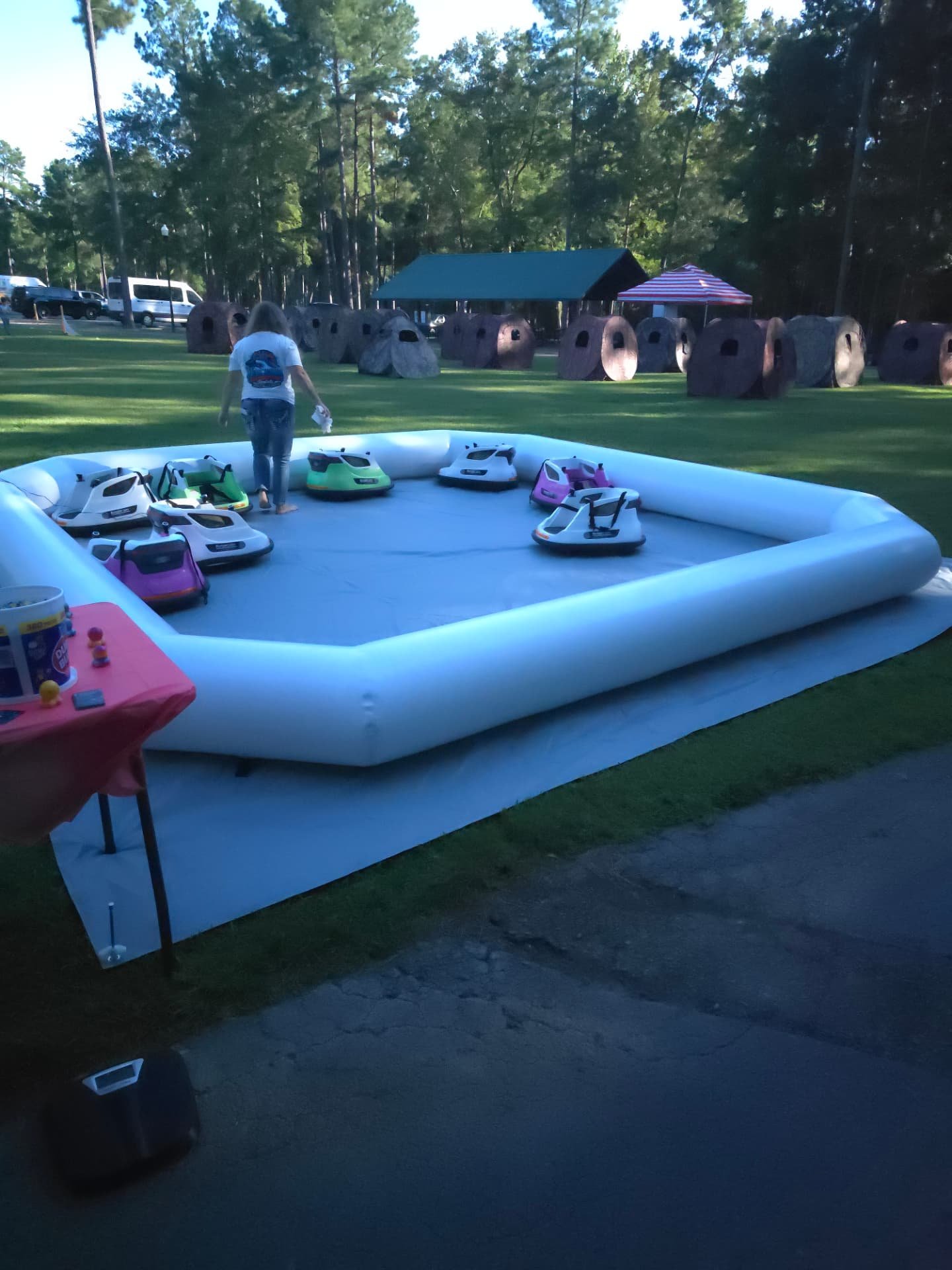 Bumper car arena on the grass with the park pavilion behind it
