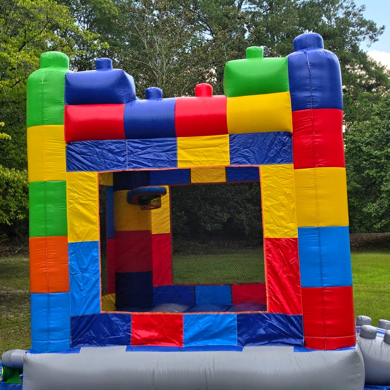 Block Party bounce house rental set up on level grass in Swansea SC with mesh safety windows and building block towers