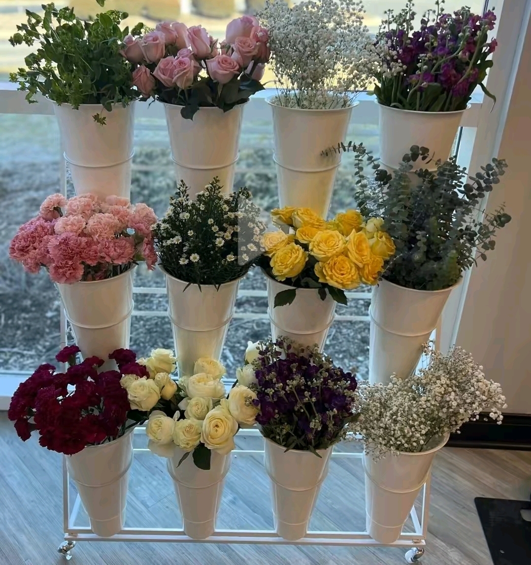 Flower bar cart with buckets of roses, carnations, and baby's breath